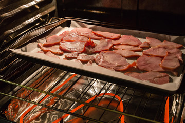 slices of back bacon baking in the oven.