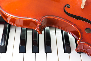 Closeup part of Violin on piano keyboard. Music instrument. Art and music background.