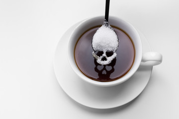 unhealthy white sugar concept. Scull spoon with sugar and cup of black coffee - obrazy, fototapety, plakaty