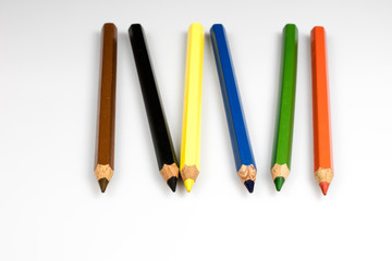 Colored pencil crayons on white isolated ground. School accessories on a white table.