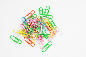 Colorful office paper clips isolated on white ground. Office accessories on a white table.