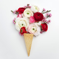 Waffle cone with composition of colorful flowers. Flat lay