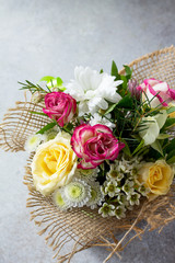 Background Mother's Day. Basket bouquet of roses and chrysanthemums on a stone background. Copy space.
