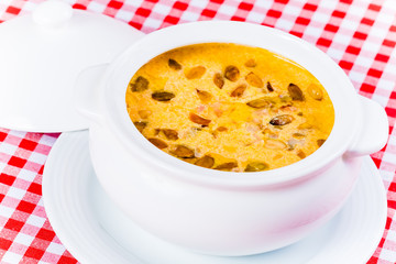 Cream soup with pumpkin in white bowl