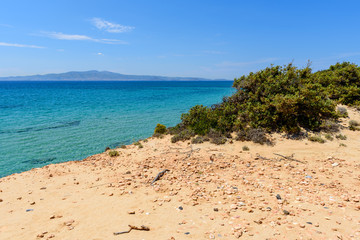 Green plants on cliff and view of crystal sea waters on Naxos island. Cyclades, Greece
