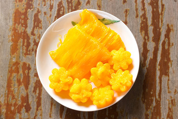 Thai dessert. Golden color dessert. Top view on wooden table. Local name Foi-Thong and Thong-Yip.