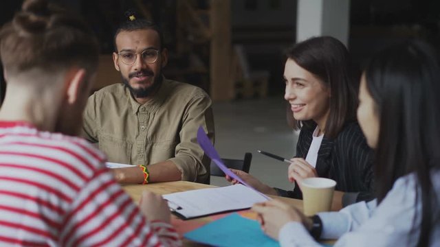 Young african american man discussing new project with multi-ethnic team in modern start-up office