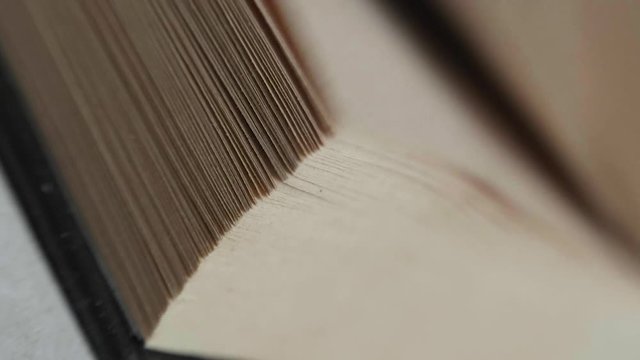 A man flips through pages in a book. Slowmotion, 180fps