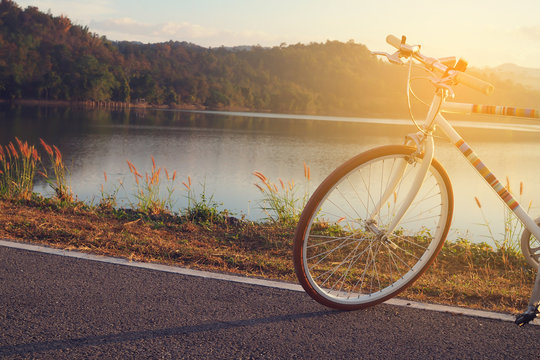 vintage bicycle on lake water, mountain in morning. concept of exercise in morning.