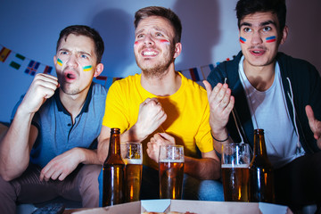 Soccer or football fans watching the match at home, cheering and celebrating goal