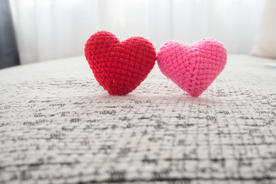 Beautiful couple knitted fabric heart shape on fabric texture on white curtain windows background texture, view front front heart sign, concept of valentine's day.