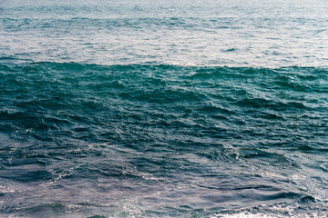 Naklejka na ściany i meble Calm ocean surface background. Beautiful dark blue sea texture. Close up.