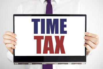 Word, writing Time Tax. Business concept for Taxation Finance Reminder Written on tablet laptop holding by the man blurred background. Businessman fingers keeping the computer.