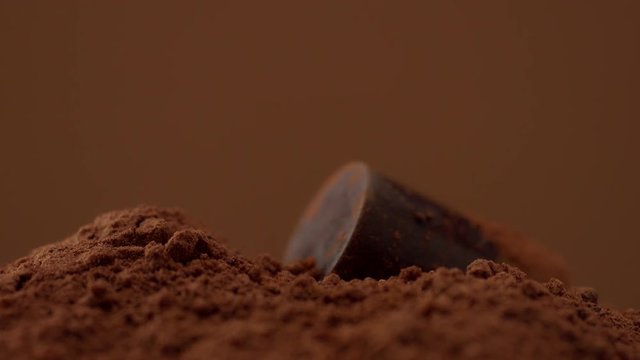 chocolate candy falling in chocolate powder mountain slowmotion