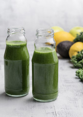Healthy smoothie with kale in bottles on the table.  Grey background.  Organic. Healthy concept.