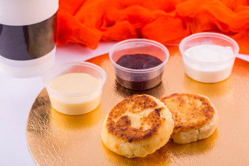 Cottage cheese cheesecakes, are served with sour cream, jam or condensed milk