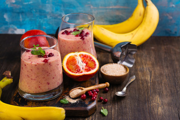 Healthy refreshing pink smoothie with apple, red oranges, cowberry and bran