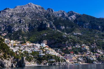 Fototapeta na wymiar View from the sea to the Italian city with colorful houses on the mountains. Amalfi Coast - architectural and travel background