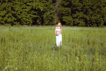 Pregnant woman in the grass.