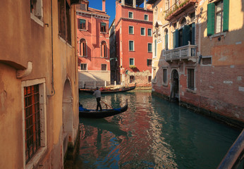 Fototapeta na wymiar Narrow Venice channel with gondoliers. Italy.