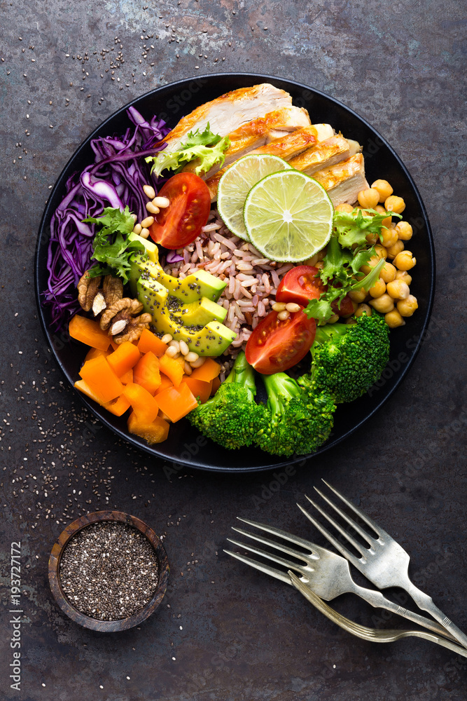 Canvas Prints Buddha bowl dish with chicken fillet, brown rice, avocado, pepper, tomato, broccoli, red cabbage, chickpea, fresh lettuce salad, pine nuts and walnuts. Healthy balanced eating. Top view