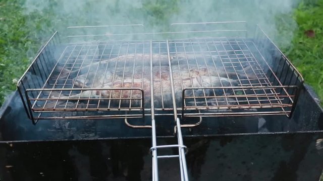 Cooking of three mackerels on a grill