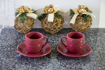 Red cup for espresso on granite table with christmas decoration