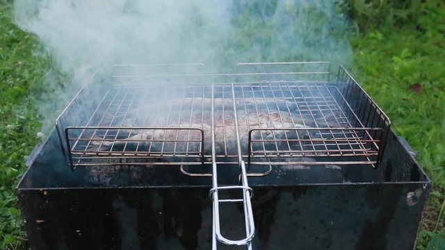 Cooking of three mackerels on a grill