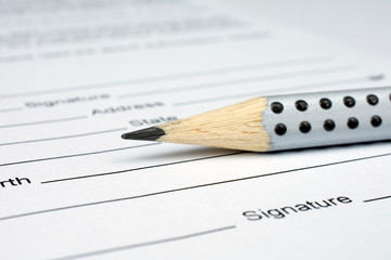 gray pencil laying over a contract waiting to be signed