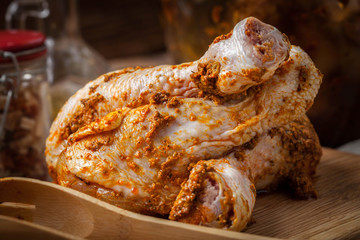 Marinated chicken drumsticks on a wooden chopping board.