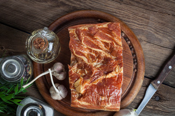 Raw bacon on a chopping board.