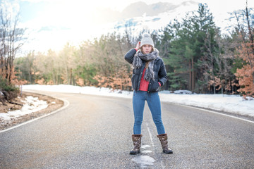 Young pretty woman on a road with snow in winter