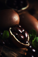 Easter composition with chocolate eggs, vintage wooden background, rustic style, selective focus