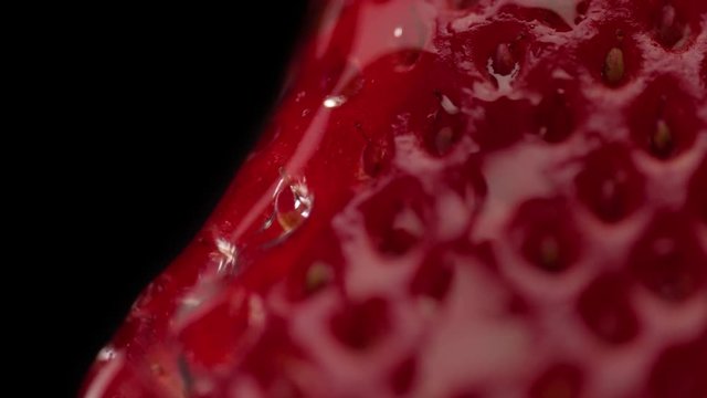 macro of strawberry texture and a trandparent drop on it moving slowly