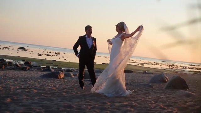 Bride and groom at the beach at sunset