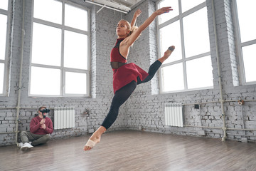 Fototapeta premium Young female dancer jumping and dancing in the gym. fashion ballet dancer. studio shot