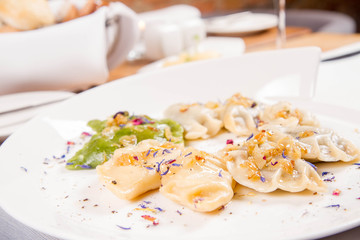 Dumplings with different kinds of stuffing decorated on a plate served in a restaurant
