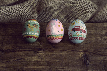 three easter eggs on a wooden board