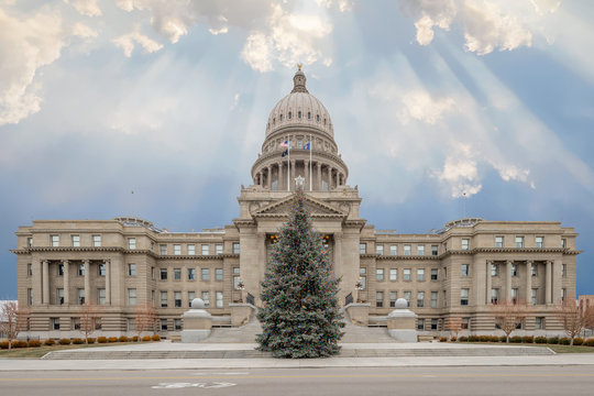 Idaho state capital building and Christmas tree with clouds and sun streaks