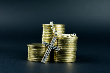 christian cross with silver chain on a gold coins, relationship of religion to money, faith,...