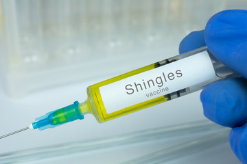 Obraz premium Vaccination healthcare concept. Hands of doctor or nurse in medical gloves with medical syringe ready for injection a shot of Shingles vaccine. close up, selective focus