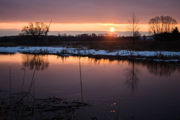 amazeing coloured winter sunrise against snowy river