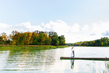 Fototapeta premium the hug of a lovers couple on the pier on the lake in a beautifu