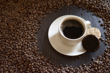 Coffee cup and coffee beans on wooden table