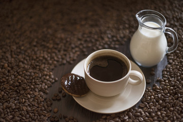 Coffee cup and coffee beans on wooden table