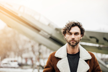 handsome man with old airplane behind outside
