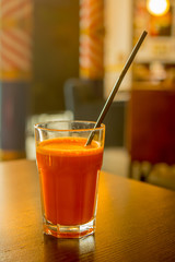 close up carrot juice in a glass stands on a table in a cafe