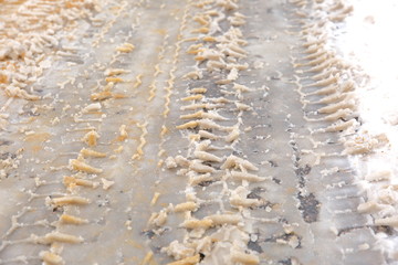 Trace of tires reflected in fresh snow.