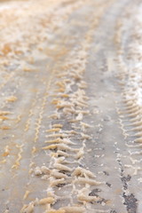 Trace of tires reflected in fresh snow.