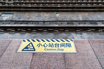 Mind the gap sign painted on train station's platform edge